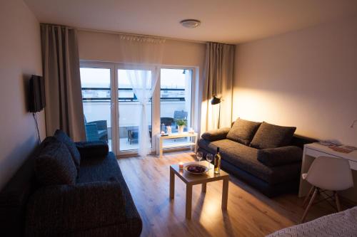 a living room with a couch and a table at Haas Apartments Stojanova with Parking in Brno
