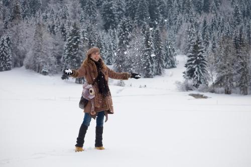 a woman is standing in the snow at Hotel Garni Tirol in Walchsee