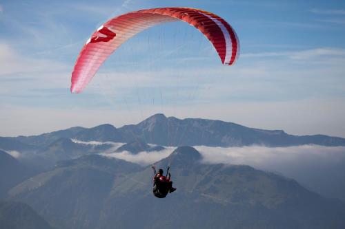 a person riding a parachute in the sky at Hotel Garni Tirol in Walchsee