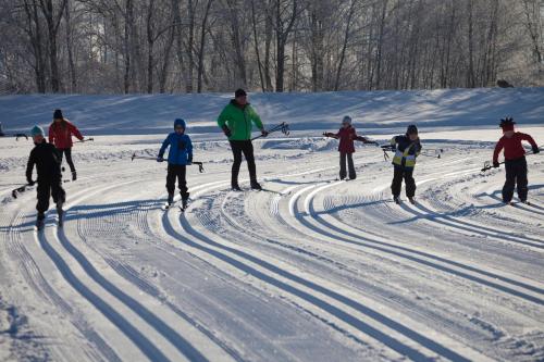 a group of people cross country skiing in the snow at Hotel Garni Tirol in Walchsee