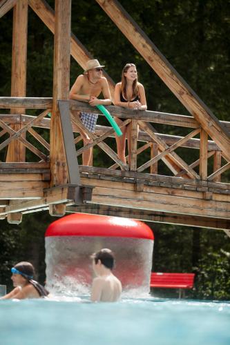 a group of people sitting at the edge of a swimming pool at Hotel Garni Tirol in Walchsee