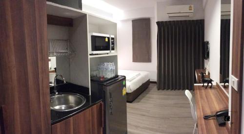 a small bathroom with a sink and a bed at Campagne Hotel and Residence - SHA Plus in Pathum Thani