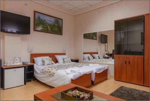 a hotel room with two beds and a flat screen tv at Olympic Residence Hotel in Prokuplje