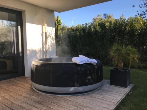 a hot tub sitting on a patio next to a house at Le Hameau de la Crique de l'Anglaise in Bandol