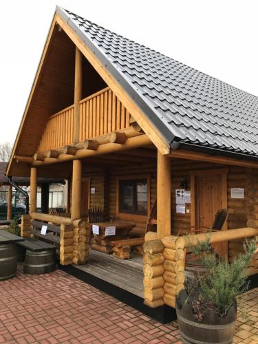 a log cabin with a dog laying on the deck at Wellness Hütte am Zwenkauer See bei Leipzig in Zwenkau