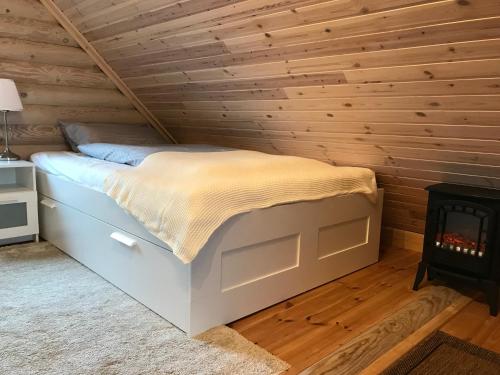 a bed in a wooden room with a fireplace at Wellness Hütte am Zwenkauer See bei Leipzig in Zwenkau