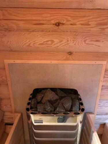 a stove top oven sitting under a wooden ceiling at Wellness Hütte am Zwenkauer See bei Leipzig in Zwenkau