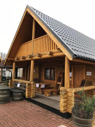 a log cabin with a porch and a roof at Wellness Hütte am Zwenkauer See bei Leipzig in Zwenkau