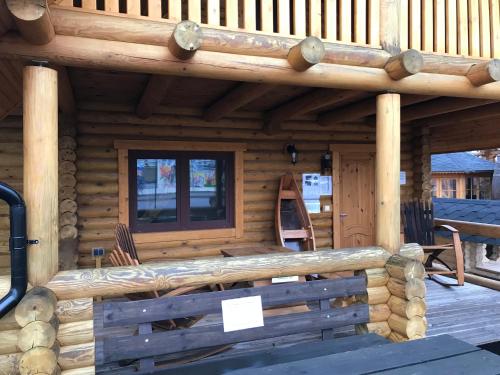 a log cabin with a porch and a window at Wellness Hütte am Zwenkauer See bei Leipzig in Zwenkau