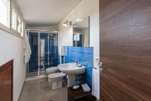 a bathroom with a white sink and a toilet at Case Spazioscena - Polimnia in Castelbuono