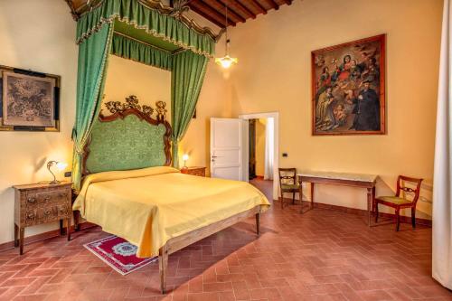 Schlafzimmer mit einem Bett mit grünem Baldachin in der Unterkunft Villa Graziani in Vada