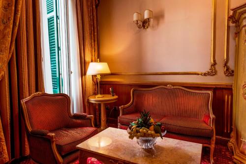 a living room with a couch and a table and chairs at Grand Hotel Wagner in Palermo