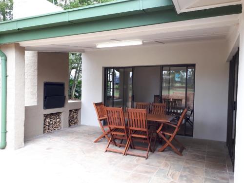 a patio with a table and chairs on a porch at De Mist Graskop in Graskop