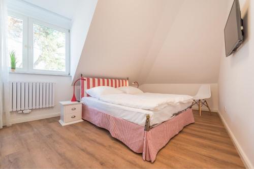 a small bedroom with a bed and a window at Min Hüsung by Rujana in Binz