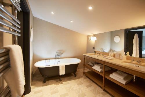 a bathroom with a bath tub and a sink at Domaine de Fontenille in Lauris