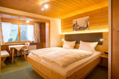 una camera da letto con un grande letto in una camera in legno di Gästehaus Tannegg a Mittelberg