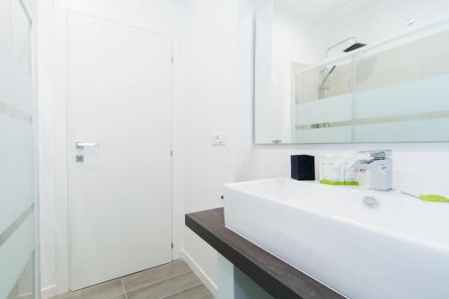 a white bathroom with a sink and a mirror at Casa Bella Pantheon in Rome