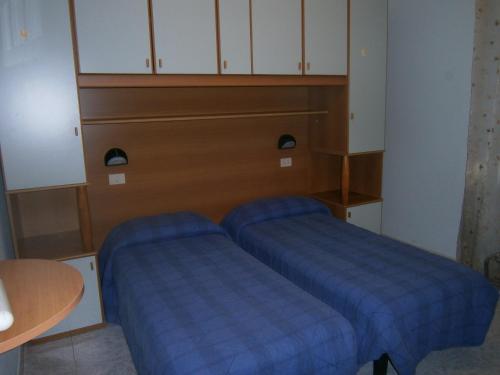 a room with two blue beds in a room at Hotel Milanesina in Alassio