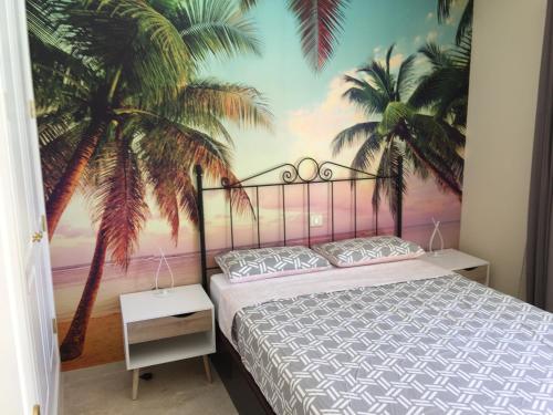 プエルトリコにあるEl Valleのベッドルーム1室(ヤシの木の壁画が施されたベッド1台付)