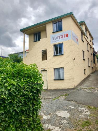 a tan building with a marato sign on it at Narrara Backpackers Hobart in Hobart
