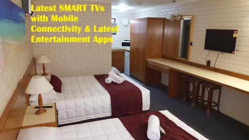 a small room with a bed and a television at Tabourie Lake Motor Inn in Ulladulla