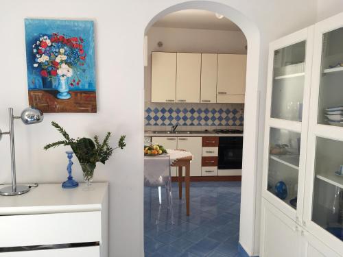 a kitchen with a table and a painting on the wall at Villa Petit Ludovica in Ravello