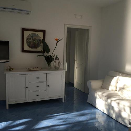 a living room with a white couch and a dresser at Villa Petit Ludovica in Ravello