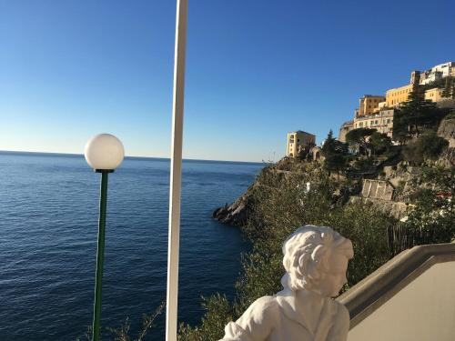 a statue of a bust sitting next to the ocean at Villa Petit Ludovica in Ravello