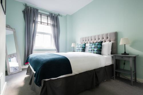 a bedroom with a large bed and a window at The Euston St Pancras Apartments in London