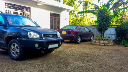 two cars parked in front of a house at Heaven Hills Guest House in Maskeliya