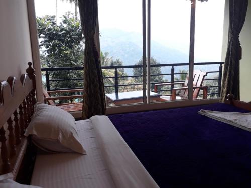 a bedroom with a bed and a balcony with a view at Green Valley Vista in Munnar