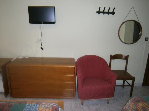 a living room with a tv and a chair and a dresser at Hotel Milanesina in Alassio
