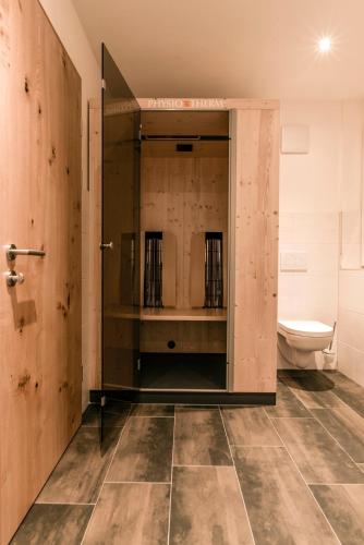 a bathroom with a toilet and a glass door at Appartements Ausblick in Sankt Gallenkirch
