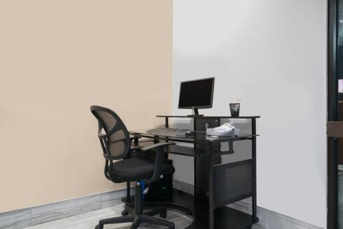 an office with a desk with a computer and a chair at Super 8 by Wyndham Rochester Mayo Clinic Area in Rochester