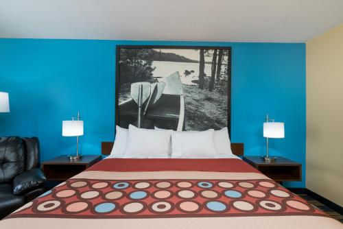a bedroom with a large bed with blue walls at Super 8 by Wyndham Rochester Mayo Clinic Area in Rochester