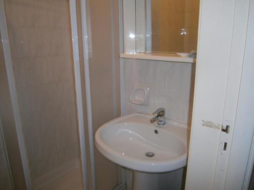 a white bathroom with a sink and a shower at Hotel Milanesina in Alassio
