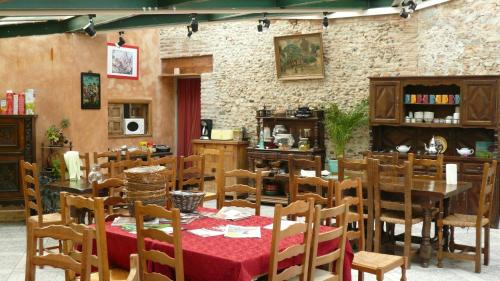 une salle à manger avec des tables et des chaises et un mur en briques dans l'établissement La Maison de Vérotte, à Claira