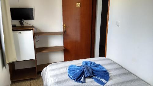 a blue bow on a bed in a room at Pousada Marambaia in Caraguatatuba