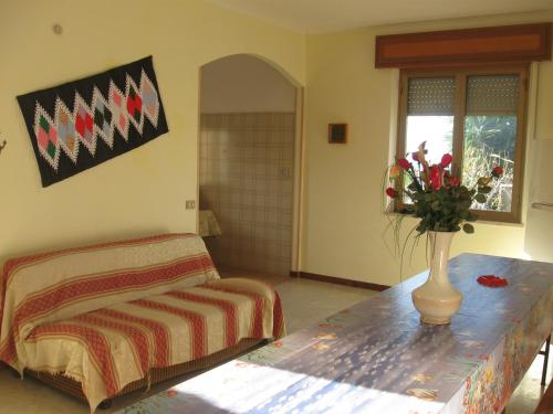 ein Schlafzimmer mit einem Bett und einem Tisch mit einer Blumenvase in der Unterkunft Valderice Vacanze for relax in Valderice