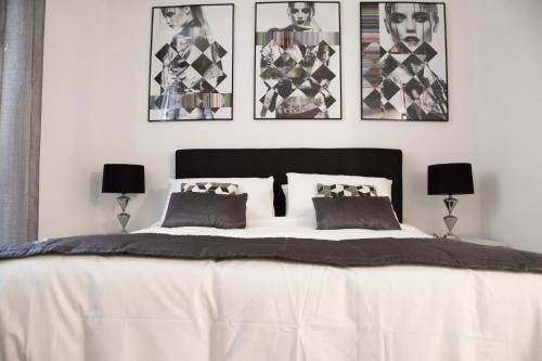 ローマにあるArgentina Exclusive Apartmentのベッドルーム1室(白い大型ベッド1台、壁に4枚の写真付)
