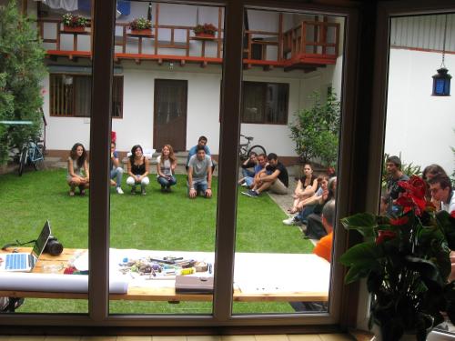 a group of people sitting on the grass in a yard at Pensiunea Amo in Vălenii de Munte