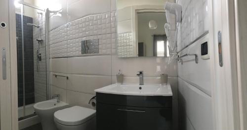 a white bathroom with a sink and a toilet at B&B Vittorio Emanuele in Licata