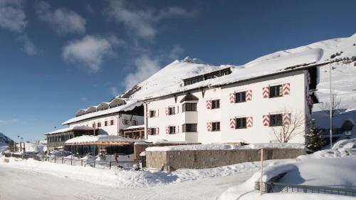 a snow covered building with a snow covered roof at Hotel Jagdschloss Resort in Kühtai
