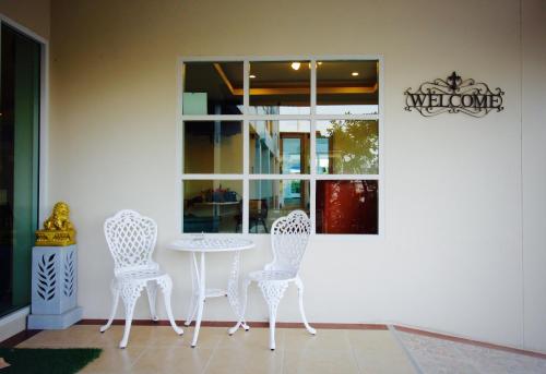 a white table and chairs in a room with a window at Green Apple Villa in Sattahip