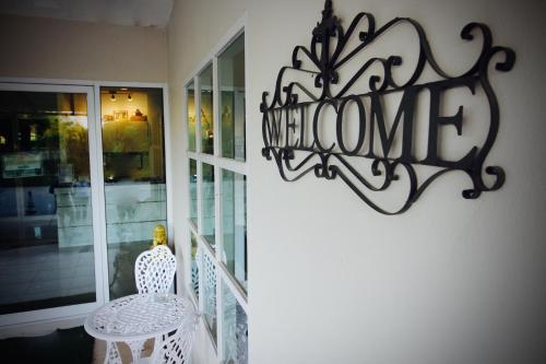 a sign on the wall of a store with a chair at Green Apple Villa in Sattahip