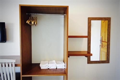 a mirror and some towels on a shelf in a room at Green Apple Villa in Sattahip