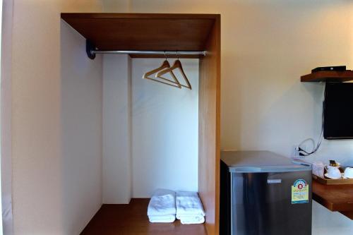 a small room with a refrigerator and a hanger at Green Apple Villa in Sattahip