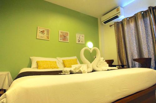 a bedroom with a bed with a swan decoration on it at Green Apple Villa in Sattahip