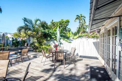 a patio with a table and chairs and a fence at Duval House in Key West
