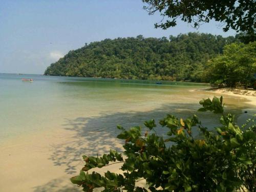 a view of a beach with a boat in the water at Baan Suan Kayoo 2 Buffalo Bay Aow Khao Kwai in Ko Phayam